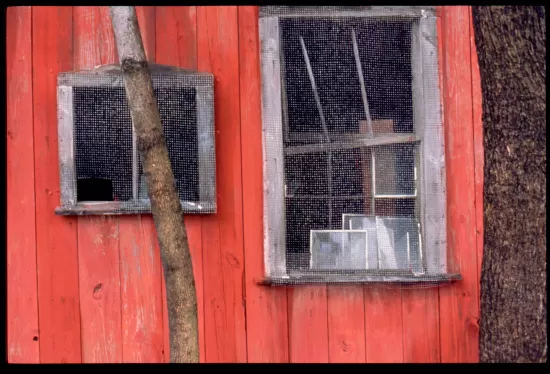 Faded red barn with screened window
