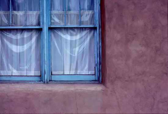 Faded blue windows in adobe wall