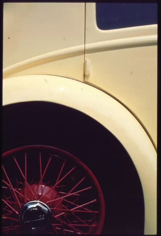 Old yellow car with red wire wheel