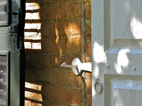 Shadows on white shutter and brick wall