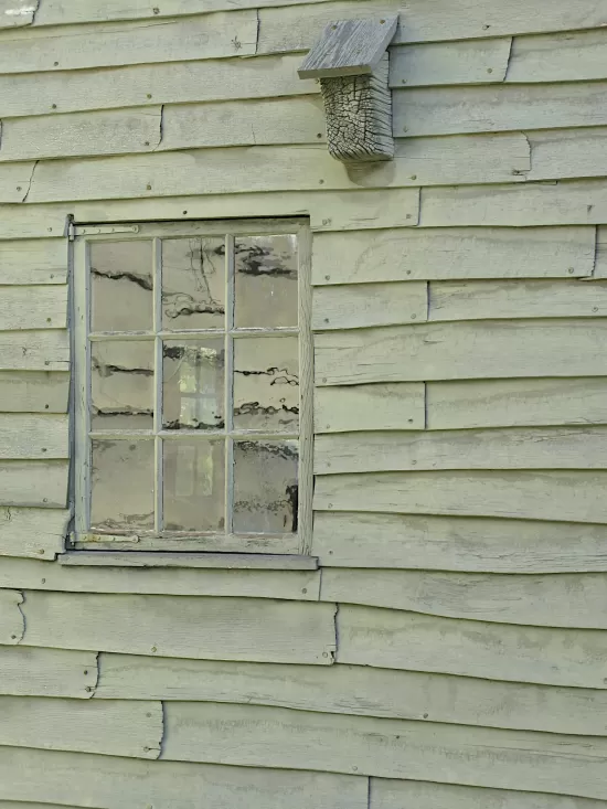 Reflections in the window of a old, clapboard building